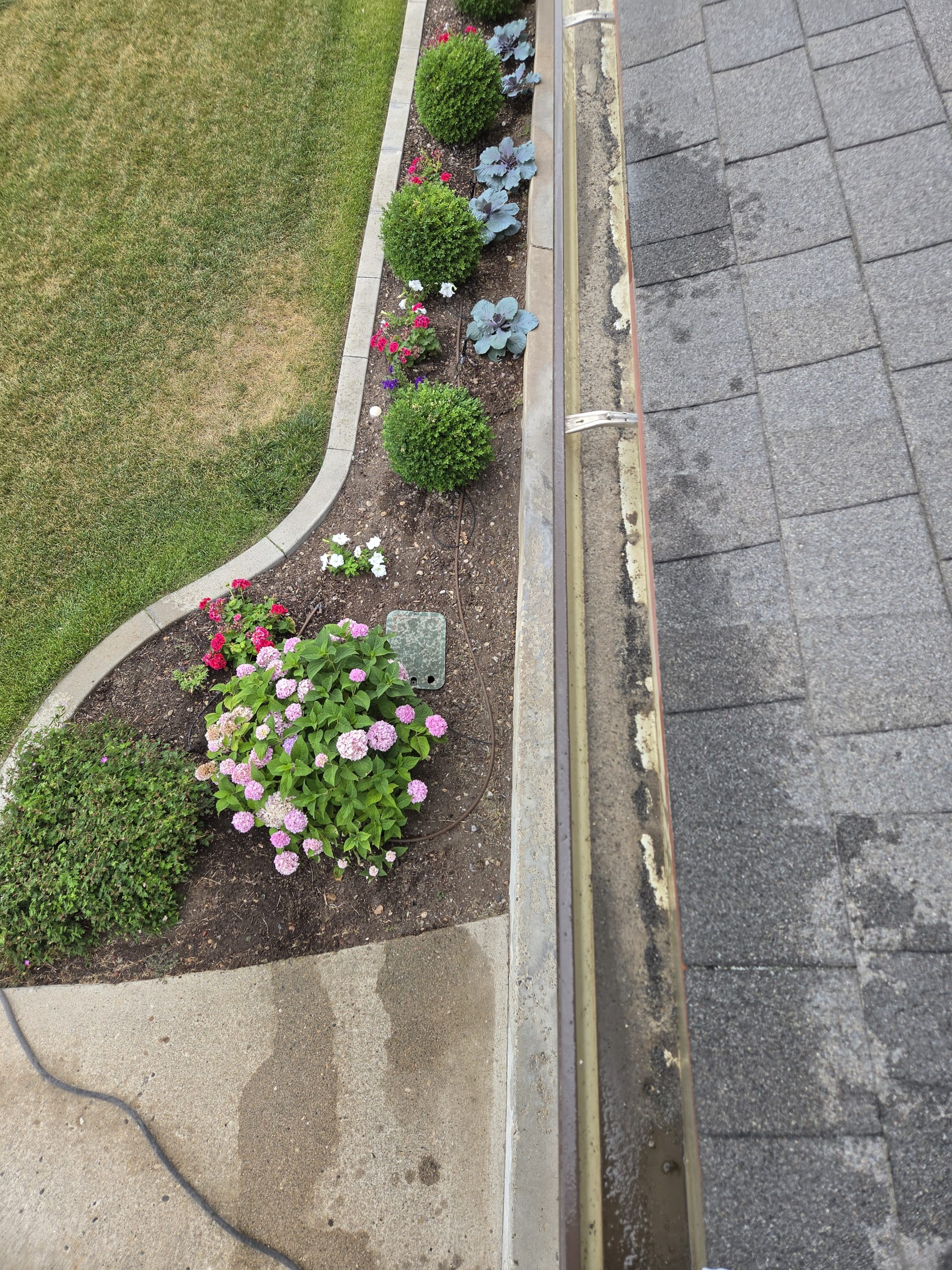 Cleared gutter running alongside a landscaped flower bed