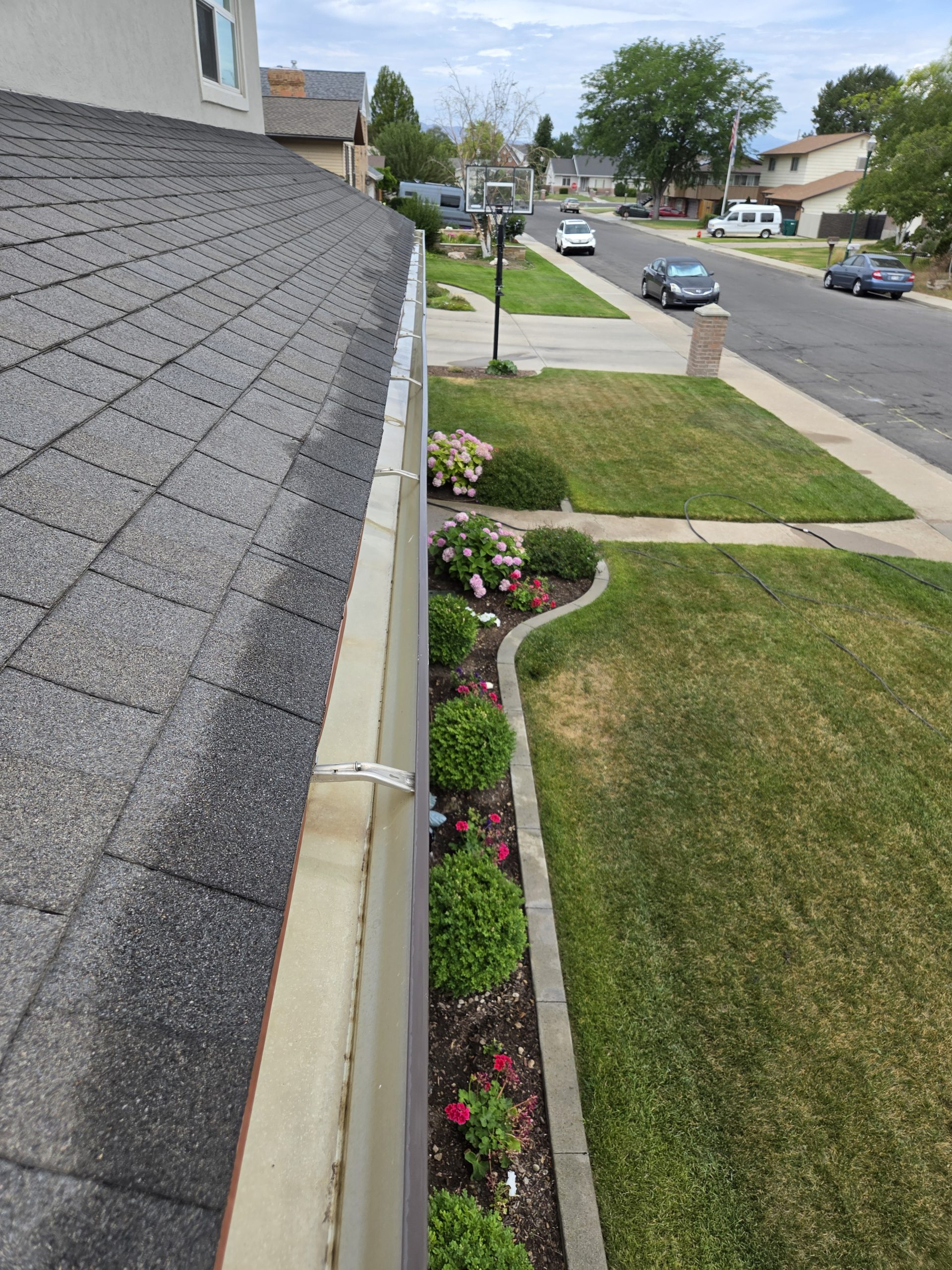 View down the roofline toward the driveway after gutter cleaning
