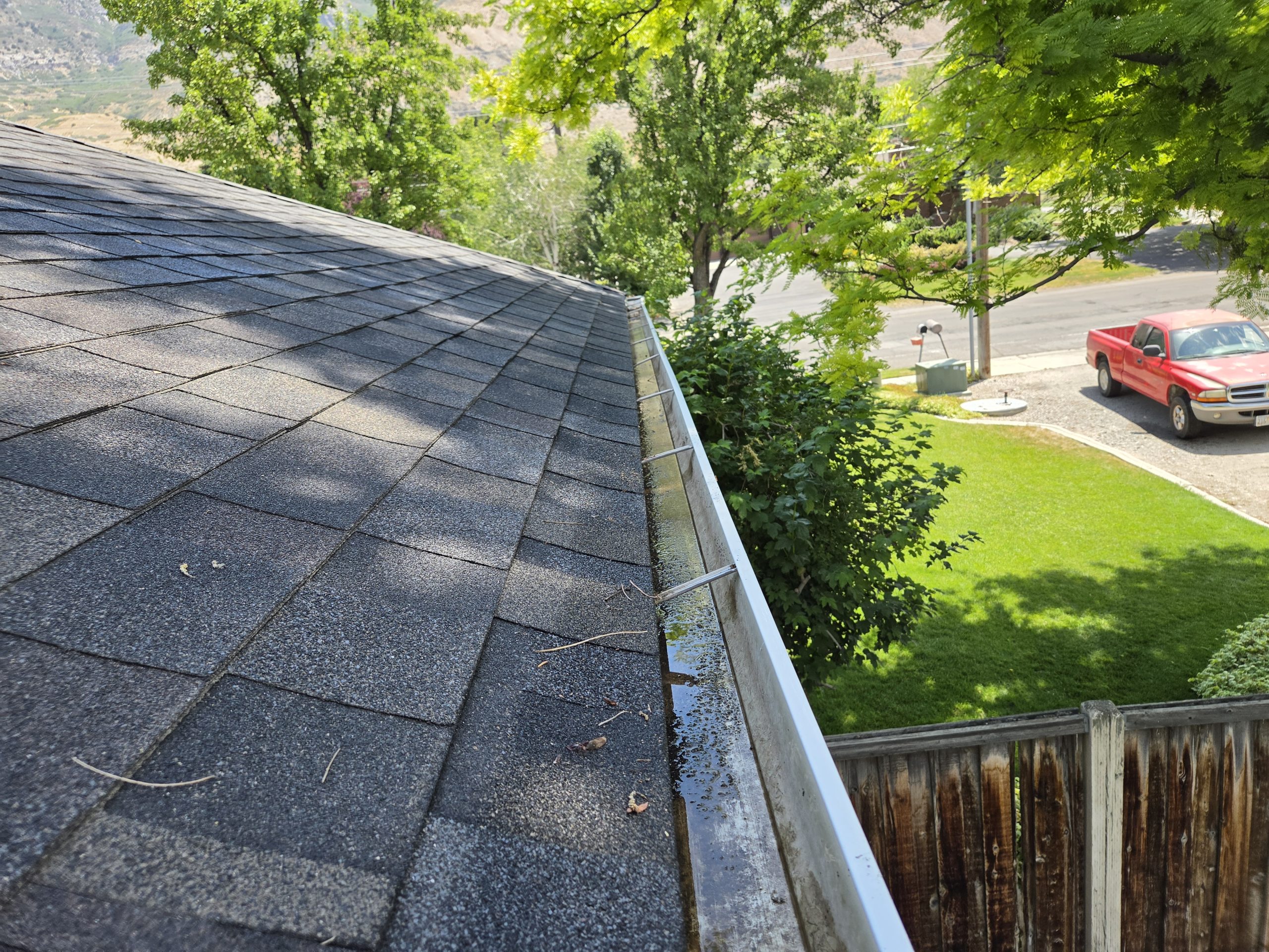View down a cleared gutter along the roofline with the street below