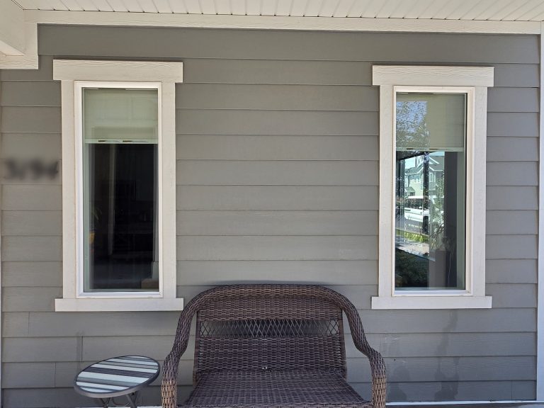 Clean windows on the covered porch, house number blurred for privacy
