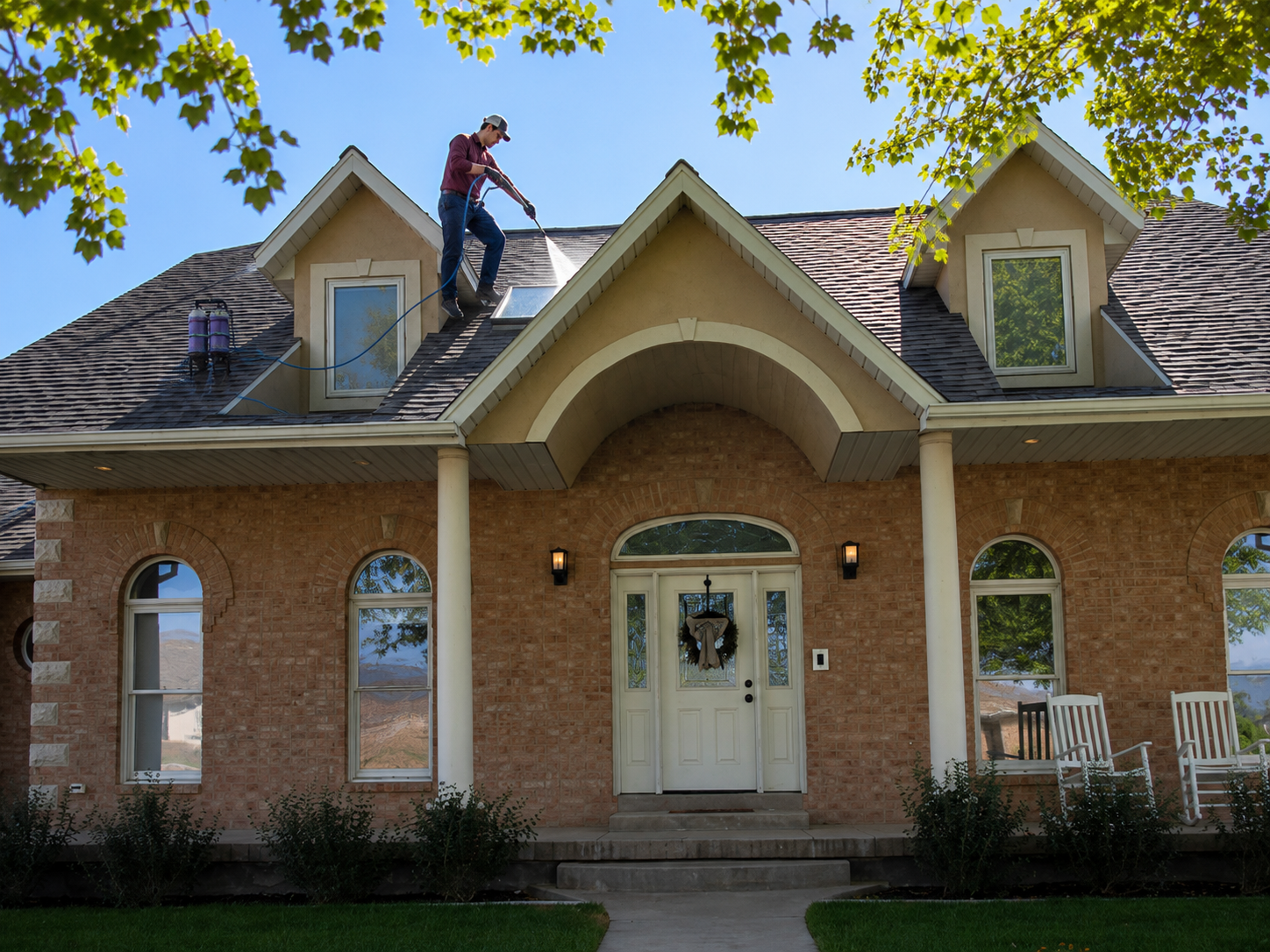 Jac rinsing an upper-story window with the DI water-fed pole while on the roof
