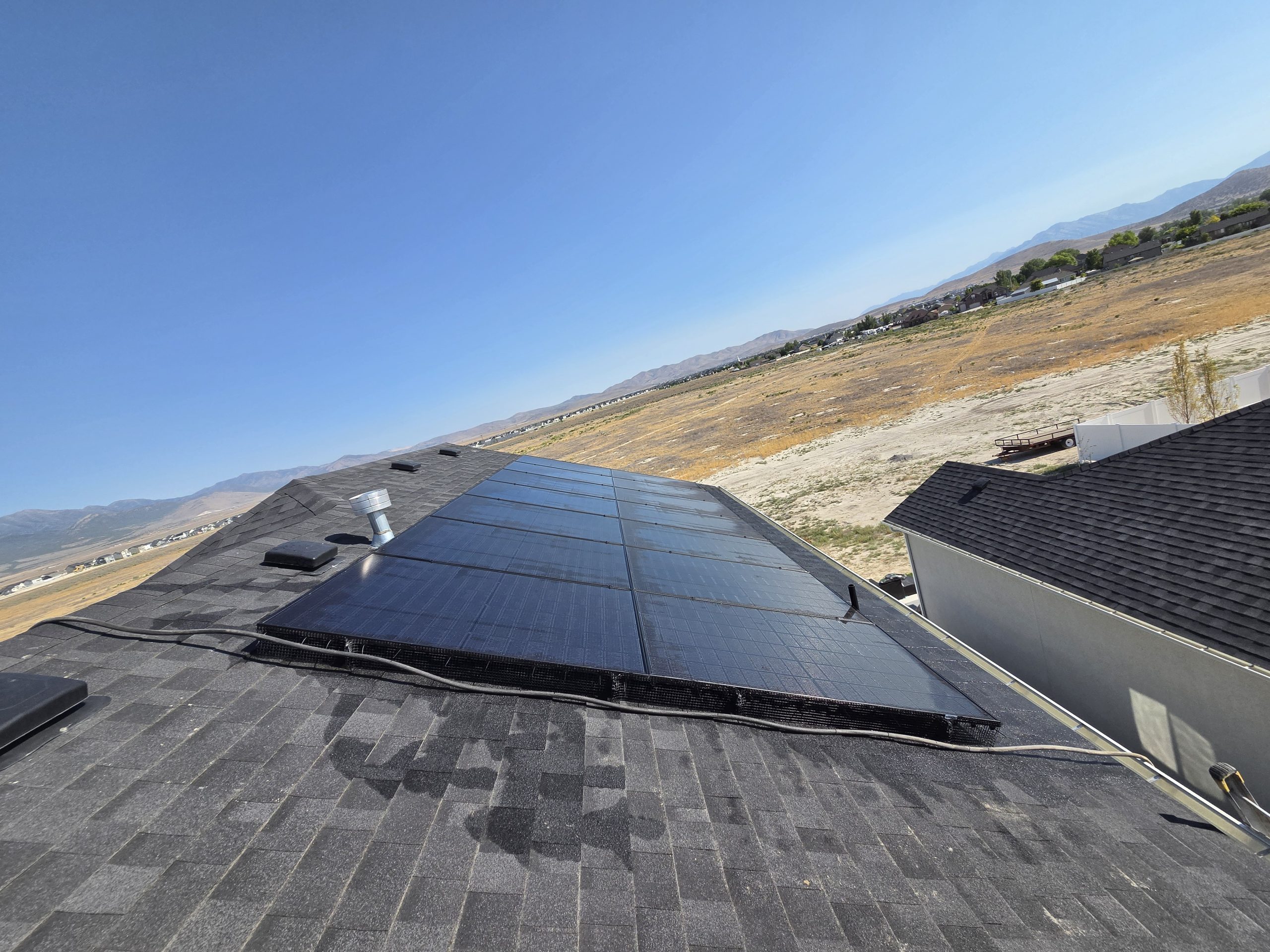 Full panel array on the roof with mountains and open land in the background